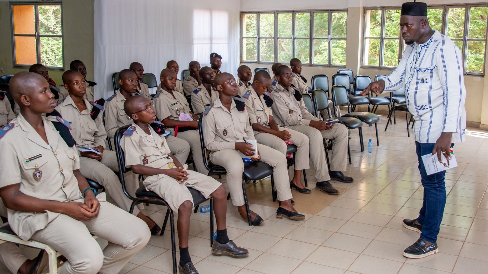 An instructor briefing a class of uniformed trainees in a training room