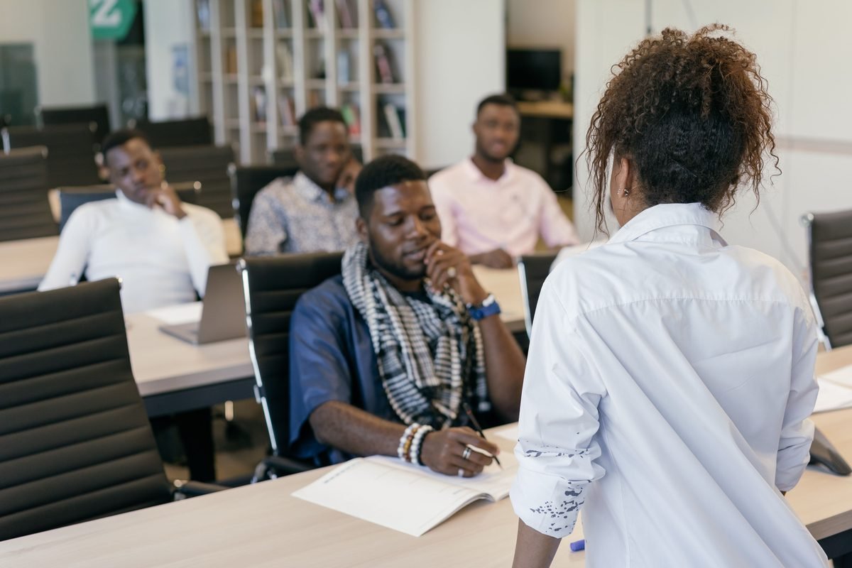 A facilitator leading a seated discussion with a small group of professionals